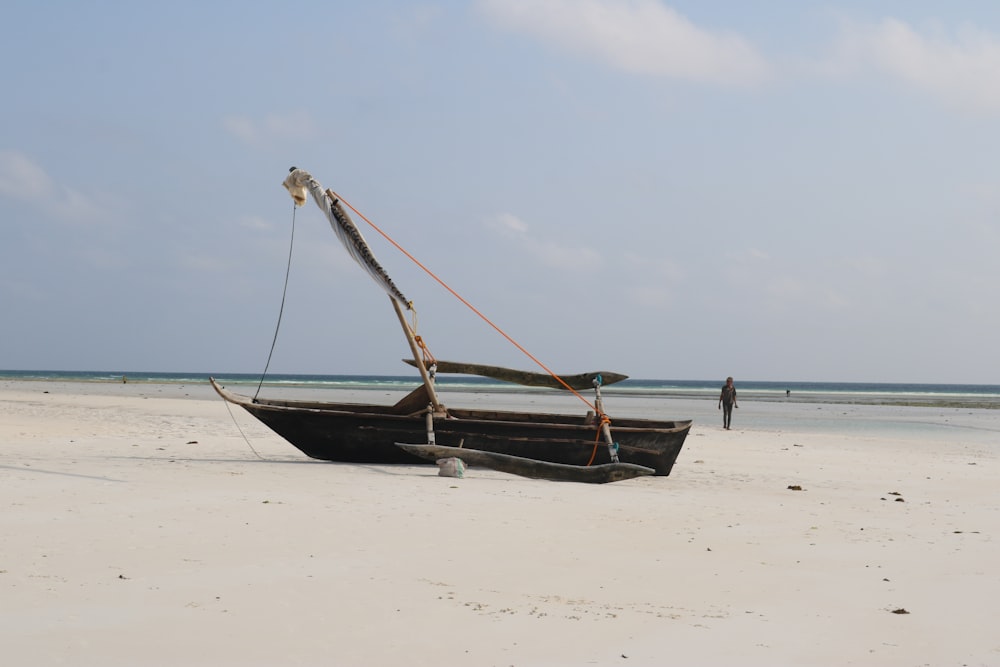 a boat sitting on top of a sandy beach