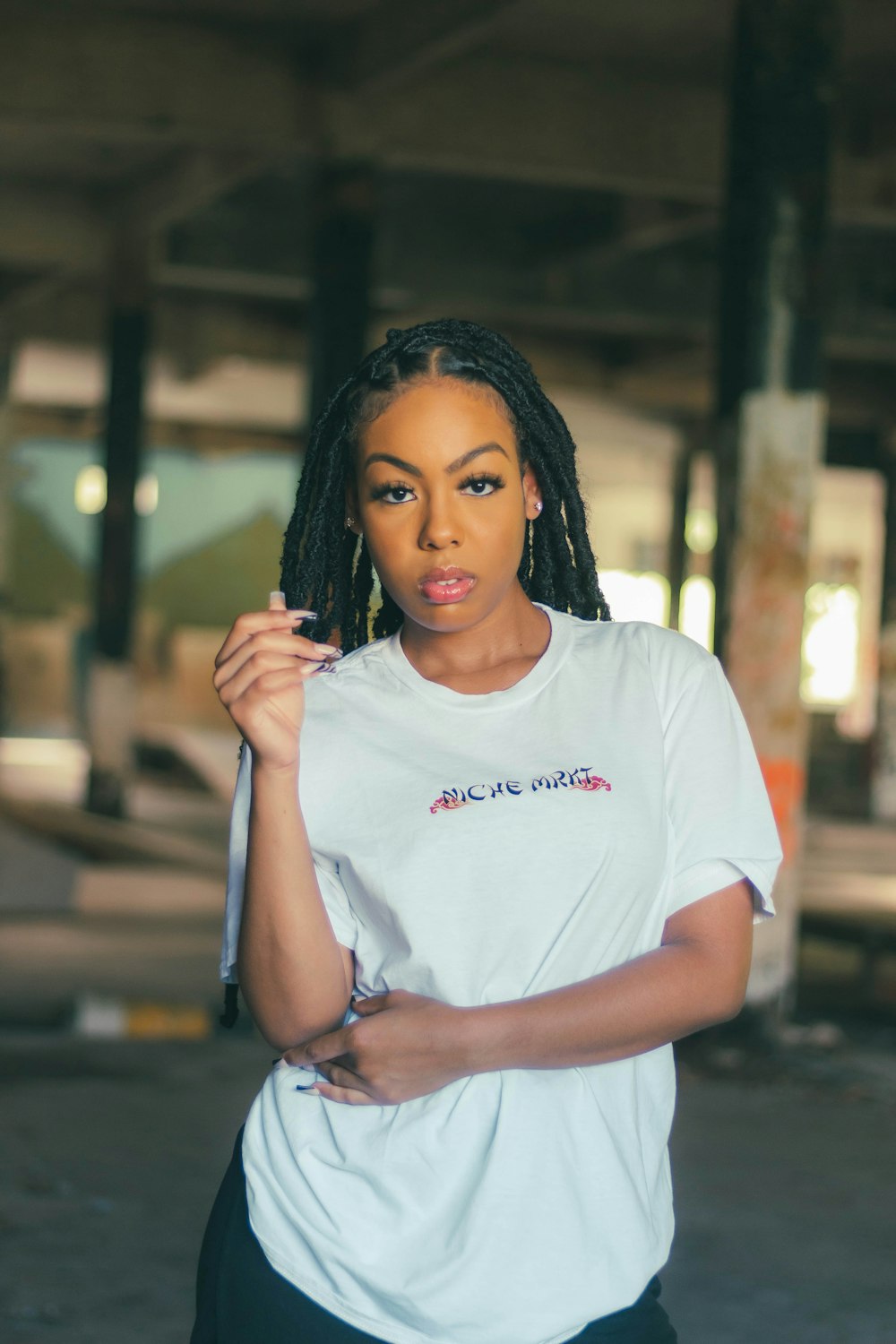 a woman with dreadlocks standing in a parking garage