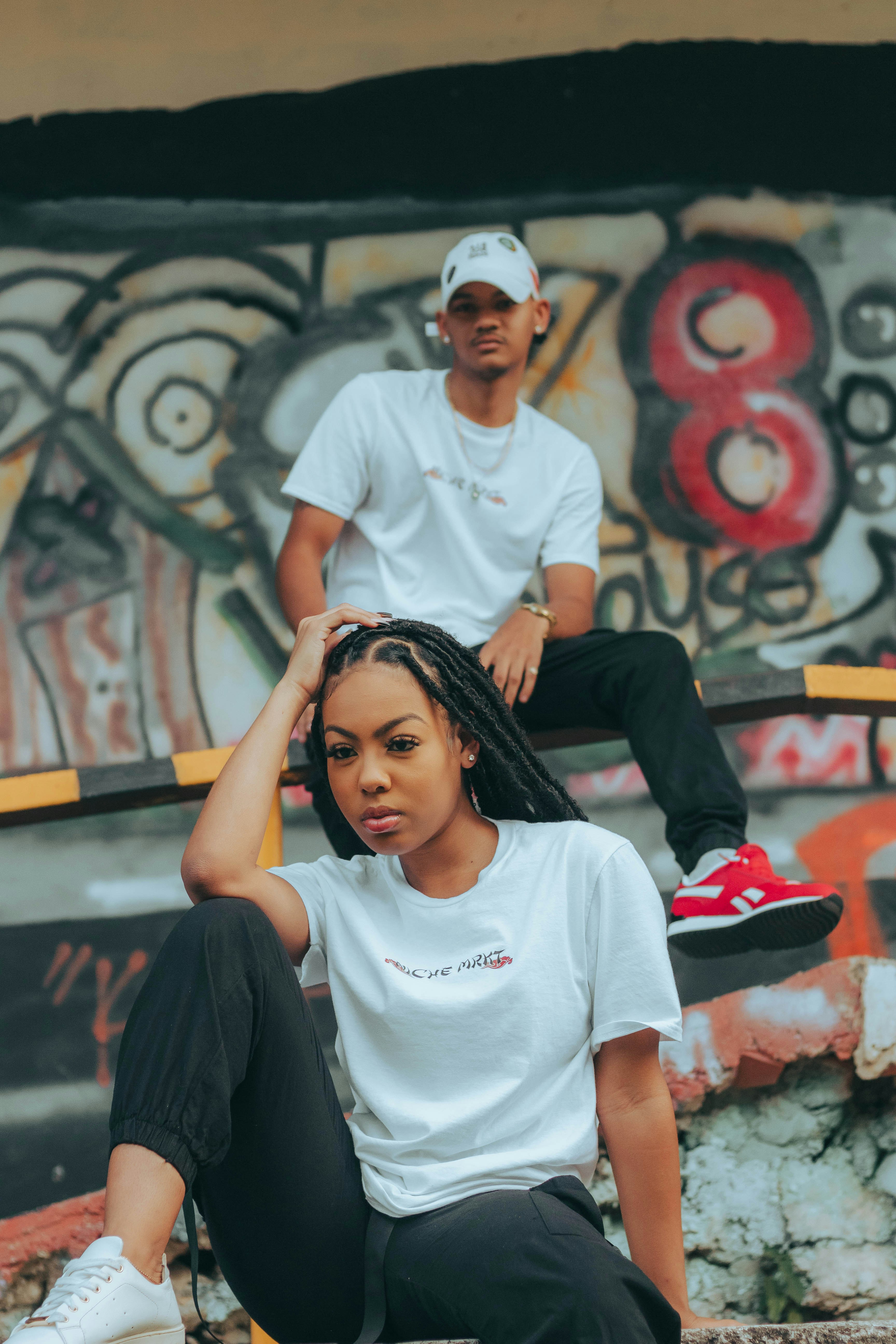 a man and a woman sitting on top of a skateboard