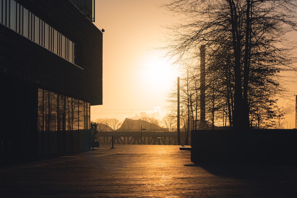 the sun is setting behind a tall building