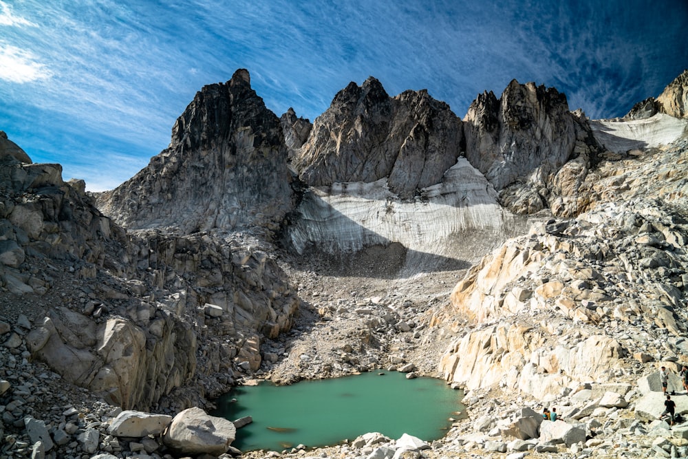 a mountain range with a lake surrounded by rocks