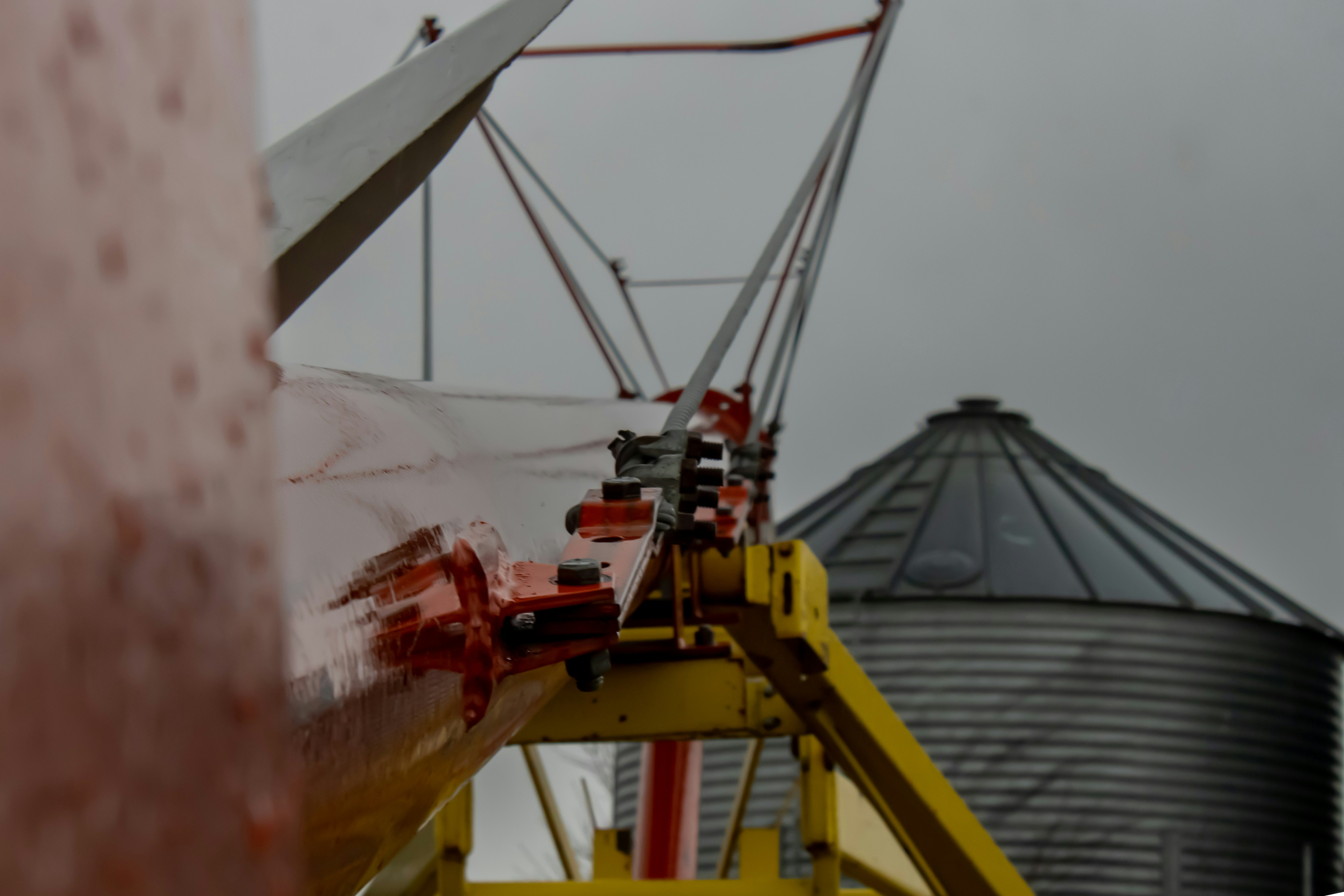 a yellow crane is next to a large silo