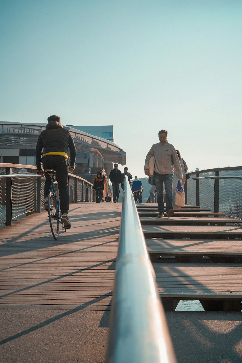 a man riding a bike across a bridge