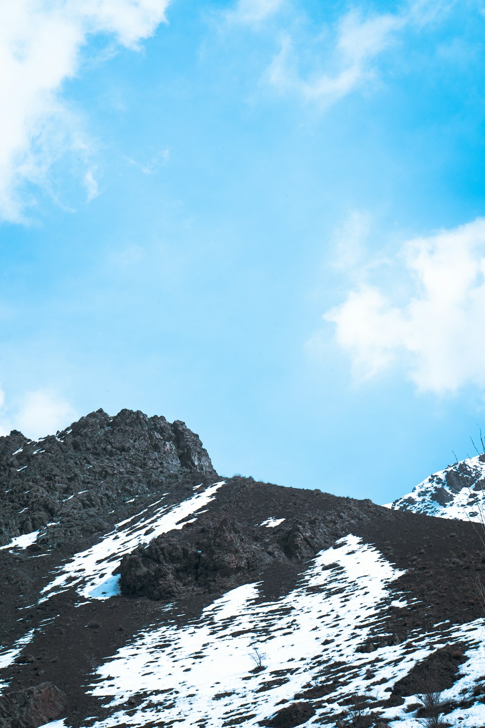 Un uomo in piedi sulla cima di una montagna coperta di neve