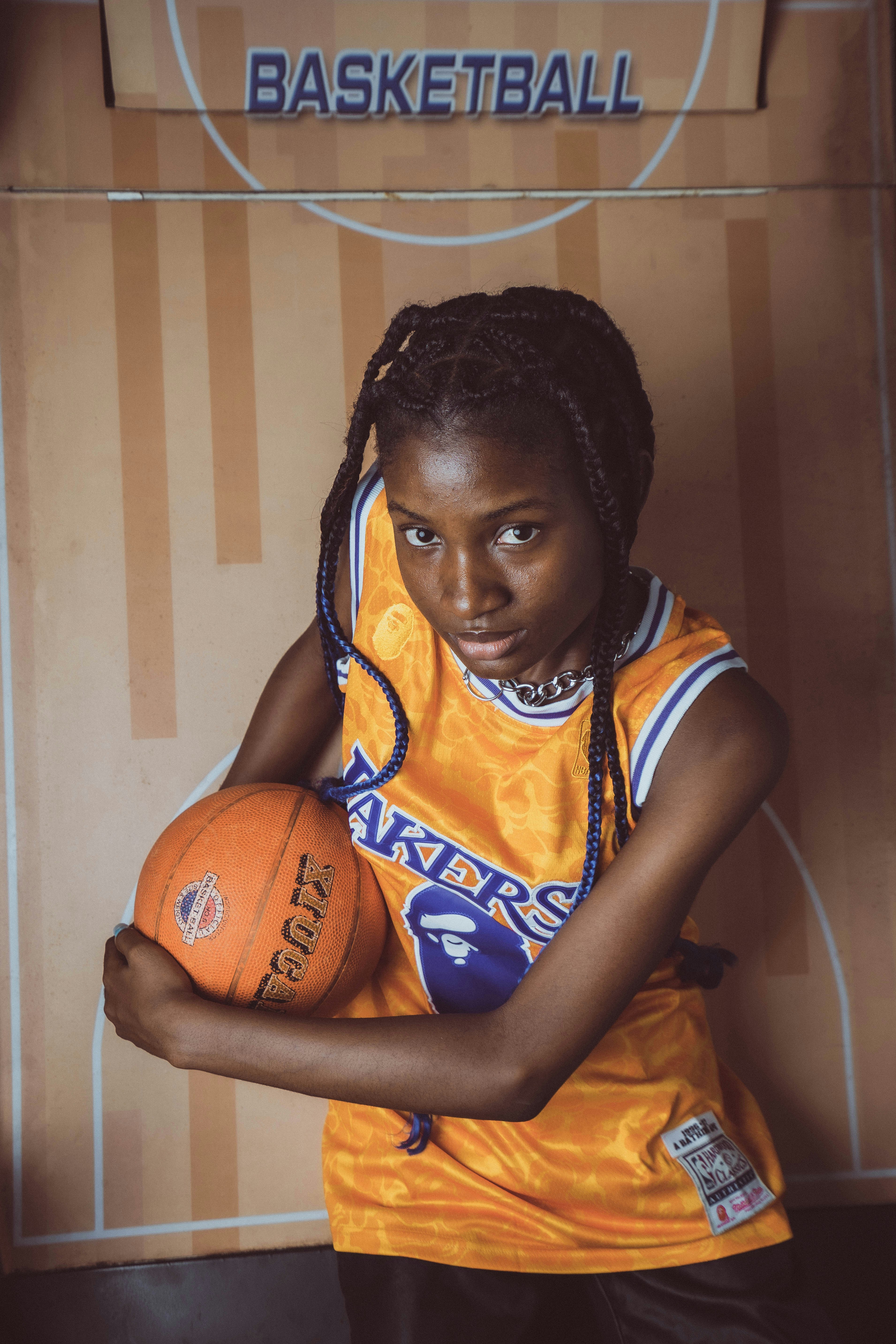a woman holding a basketball in front of a basketball court