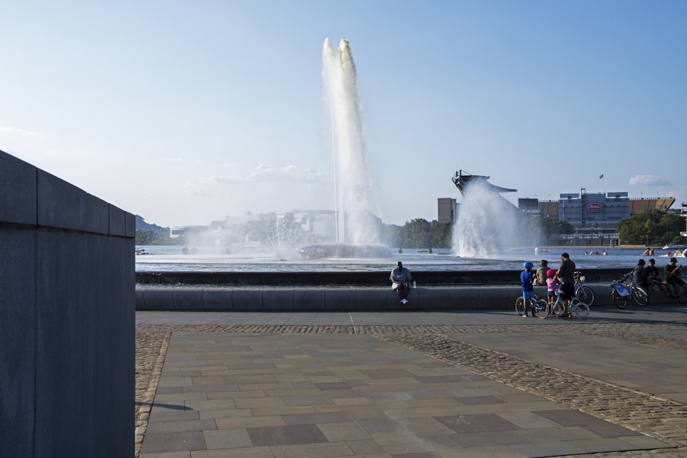 a group of people standing around a fountain