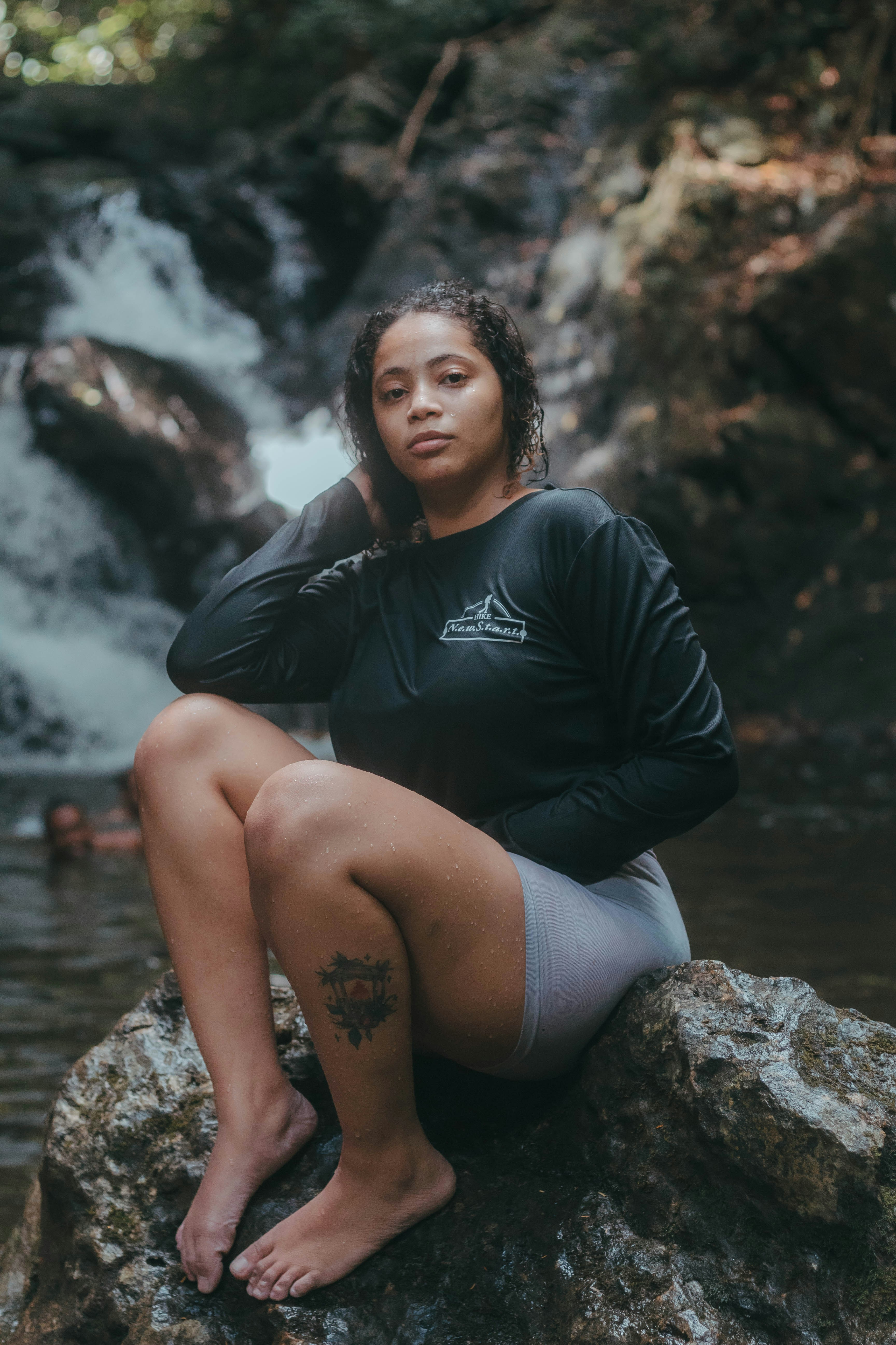 A woman sitting on a rock in front of a waterfall photo – Free Nature ...