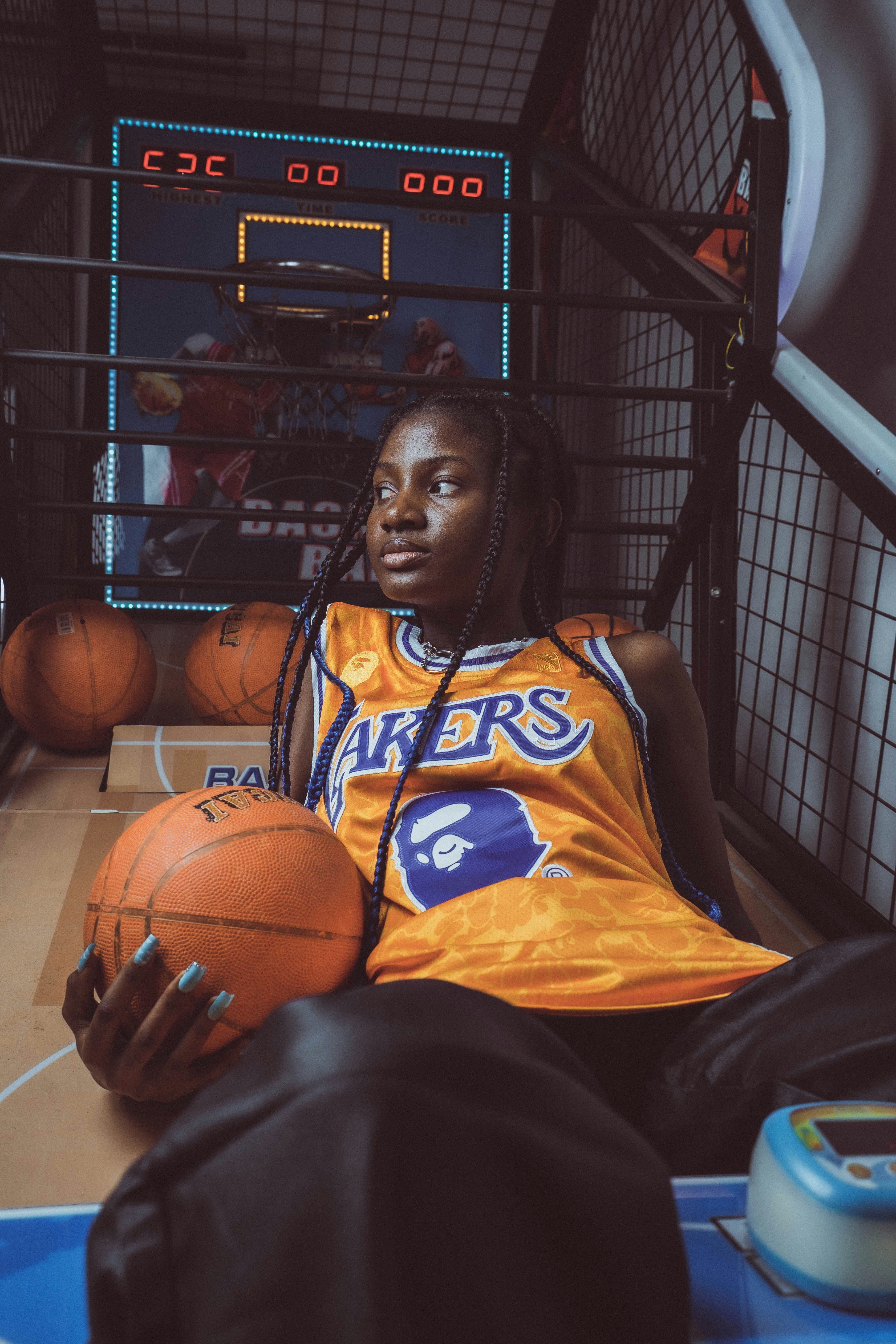 a woman sitting on a basketball court holding a basketball