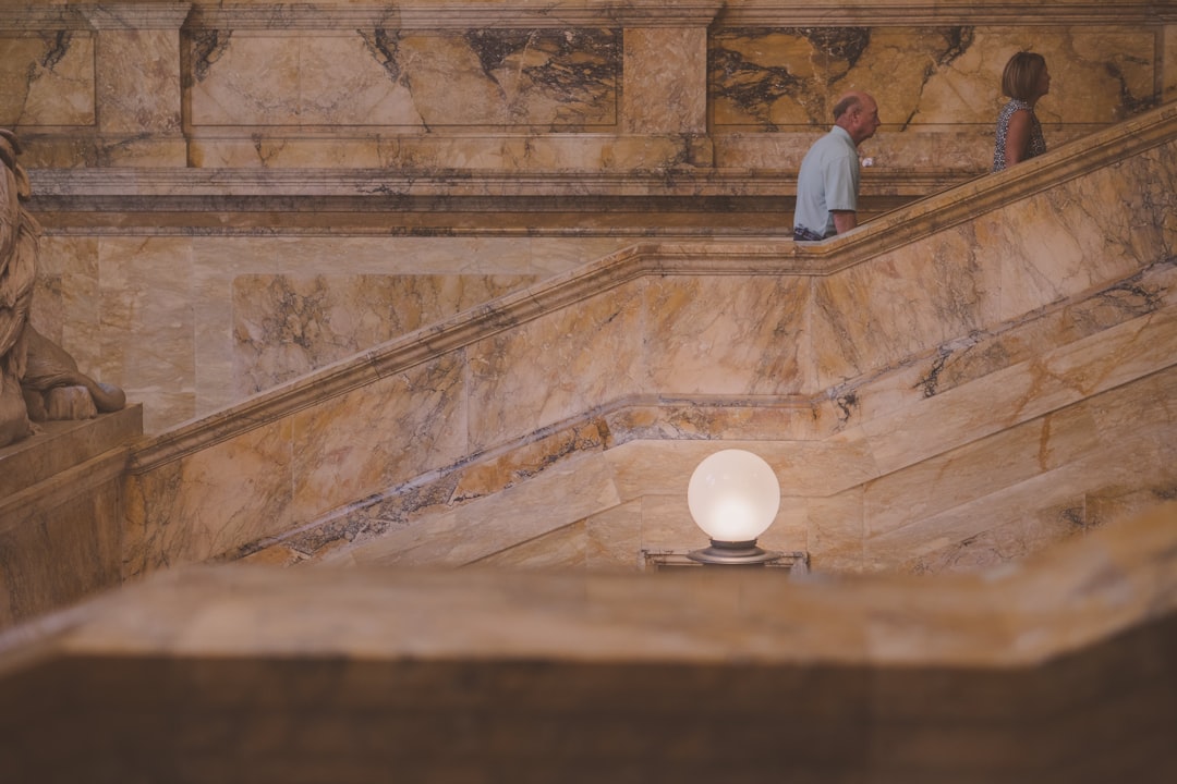 a couple of people standing on a set of stairs, Interior photos of a staircase in Boston. Beautiful marble cover steps a