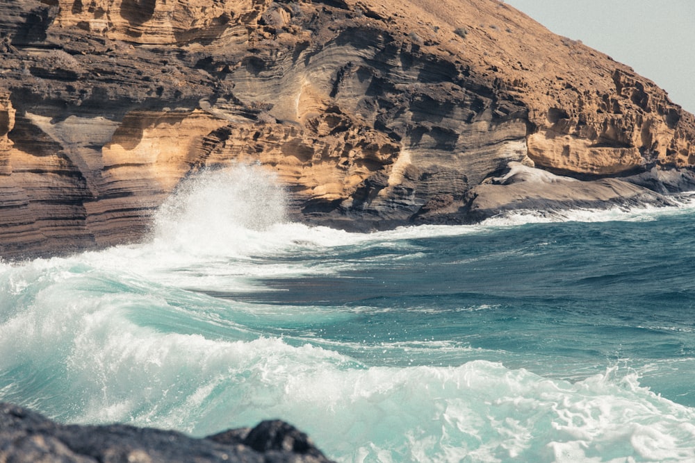 a large body of water next to a rocky cliff