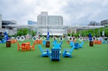 a group of blue and orange chairs sitting on top of a green field