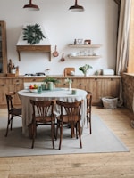 A cozy kitchen with wooden chairs and a bright atmosphere.