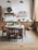A cozy kitchen scene with a wooden table filled with fresh ingredients and cooking utensils.