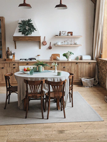 Cozy kitchen with warm wooden cabinets and a rustic farmhouse table set for breakfast.