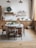 A cozy kitchen scene with a wooden table filled with fresh ingredients and cooking utensils.