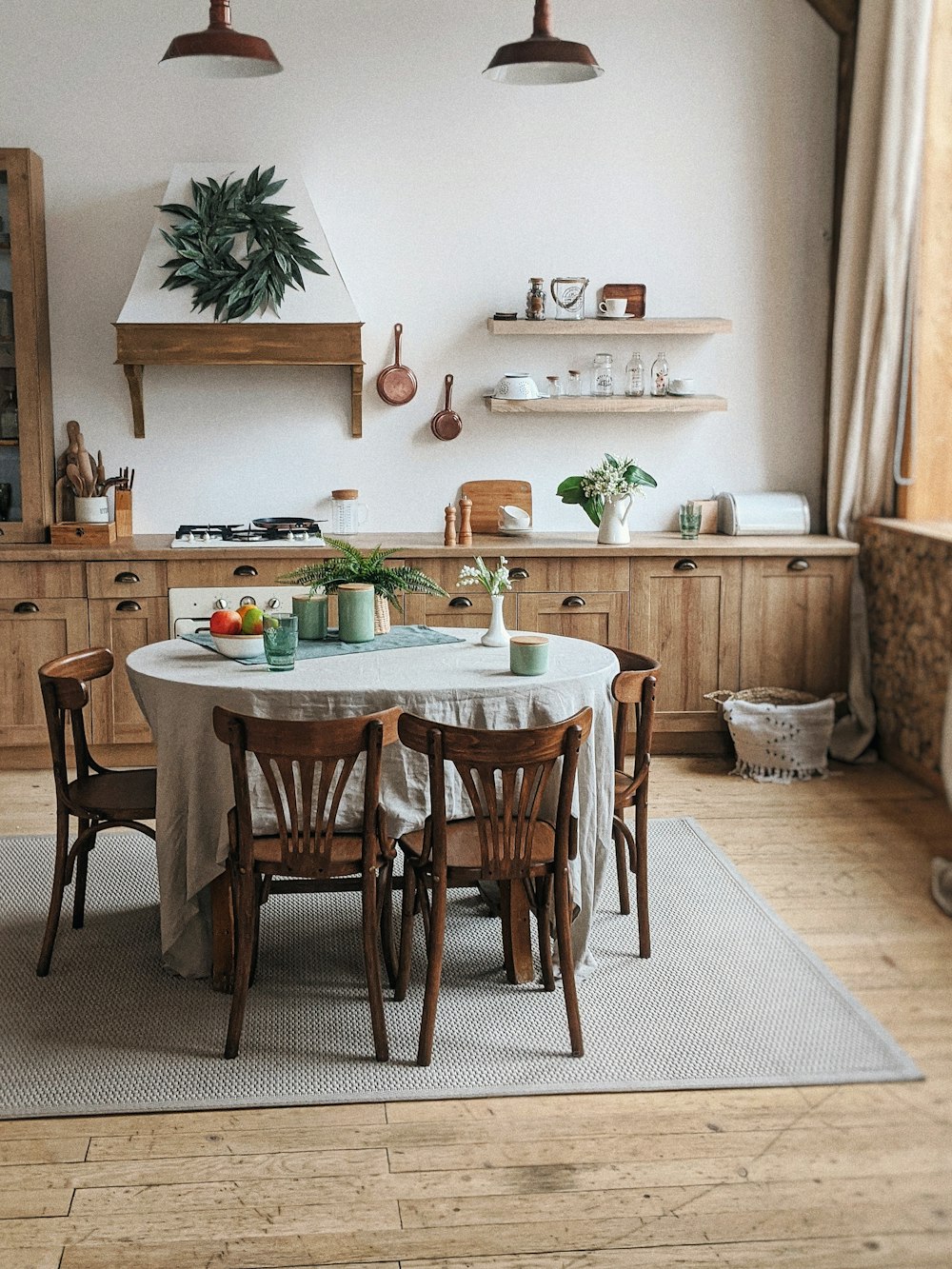 a kitchen with a table and chairs and a potted plant