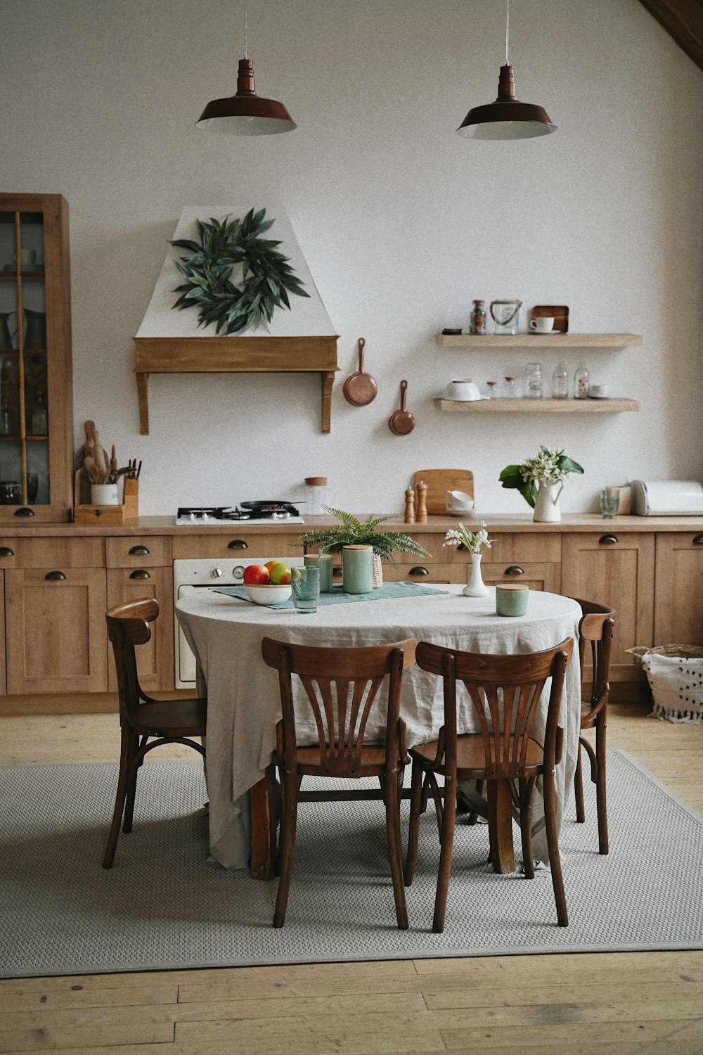 uma cozinha com uma mesa e cadeiras e um vaso de plantas