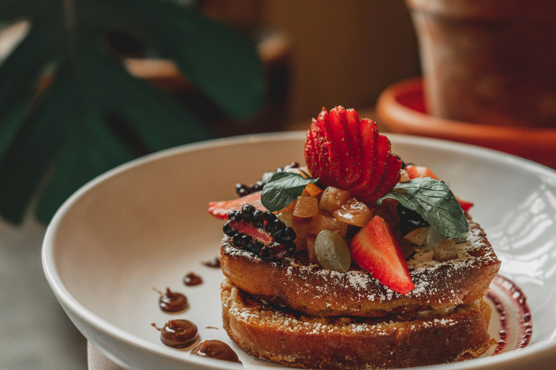 a white plate topped with french toast covered in fruit