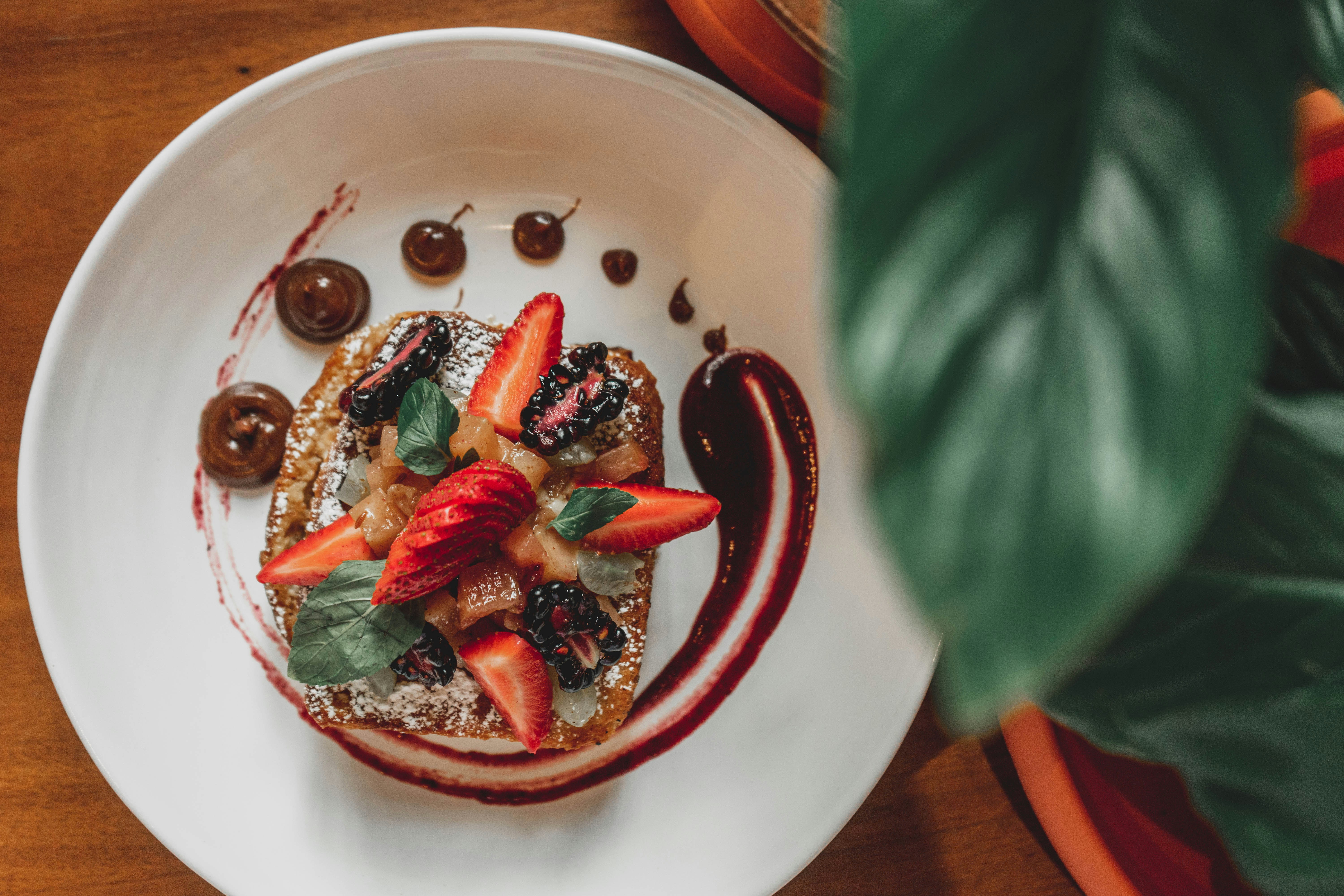 a white plate topped with a dessert covered in fruit