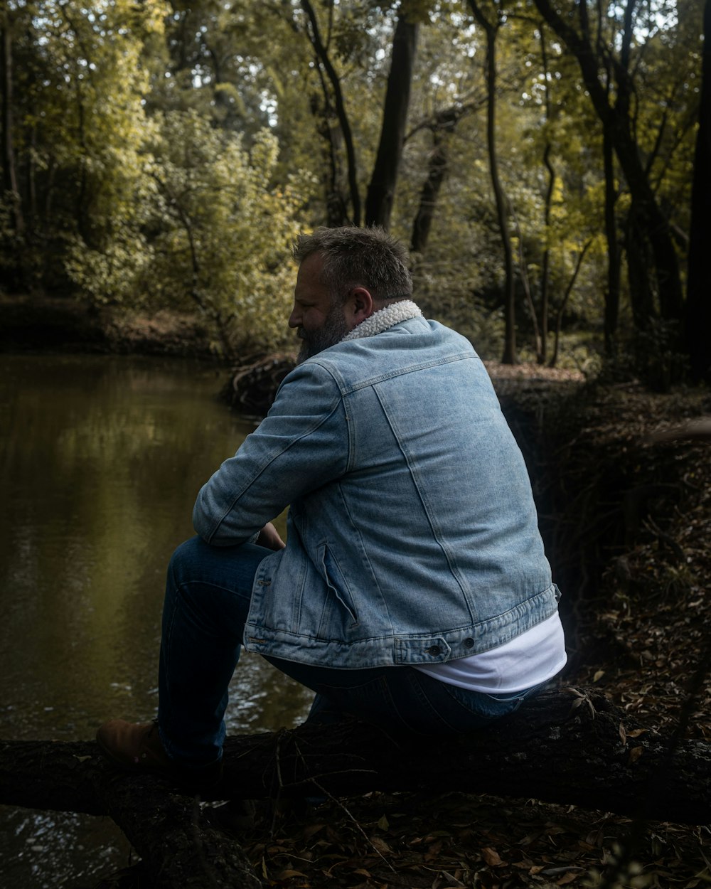 a man sitting on a log in the woods