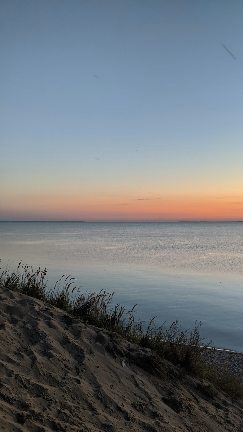 a bench sitting on top of a sandy beach