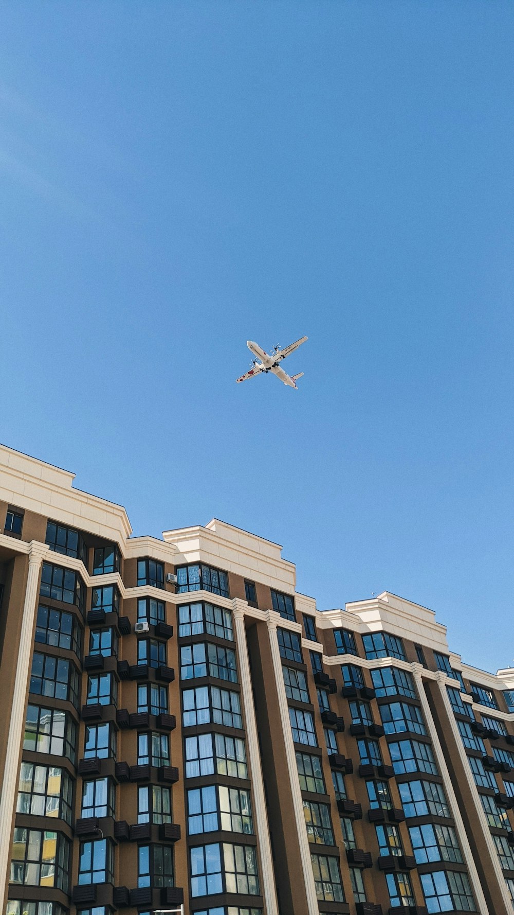 an airplane flying over a large building in the sky