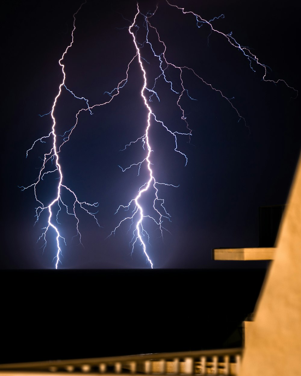 a lightning strike is seen in the sky above a building