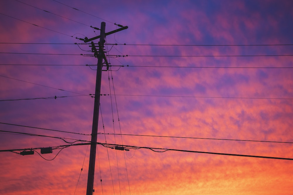 a telephone pole with a sky in the background