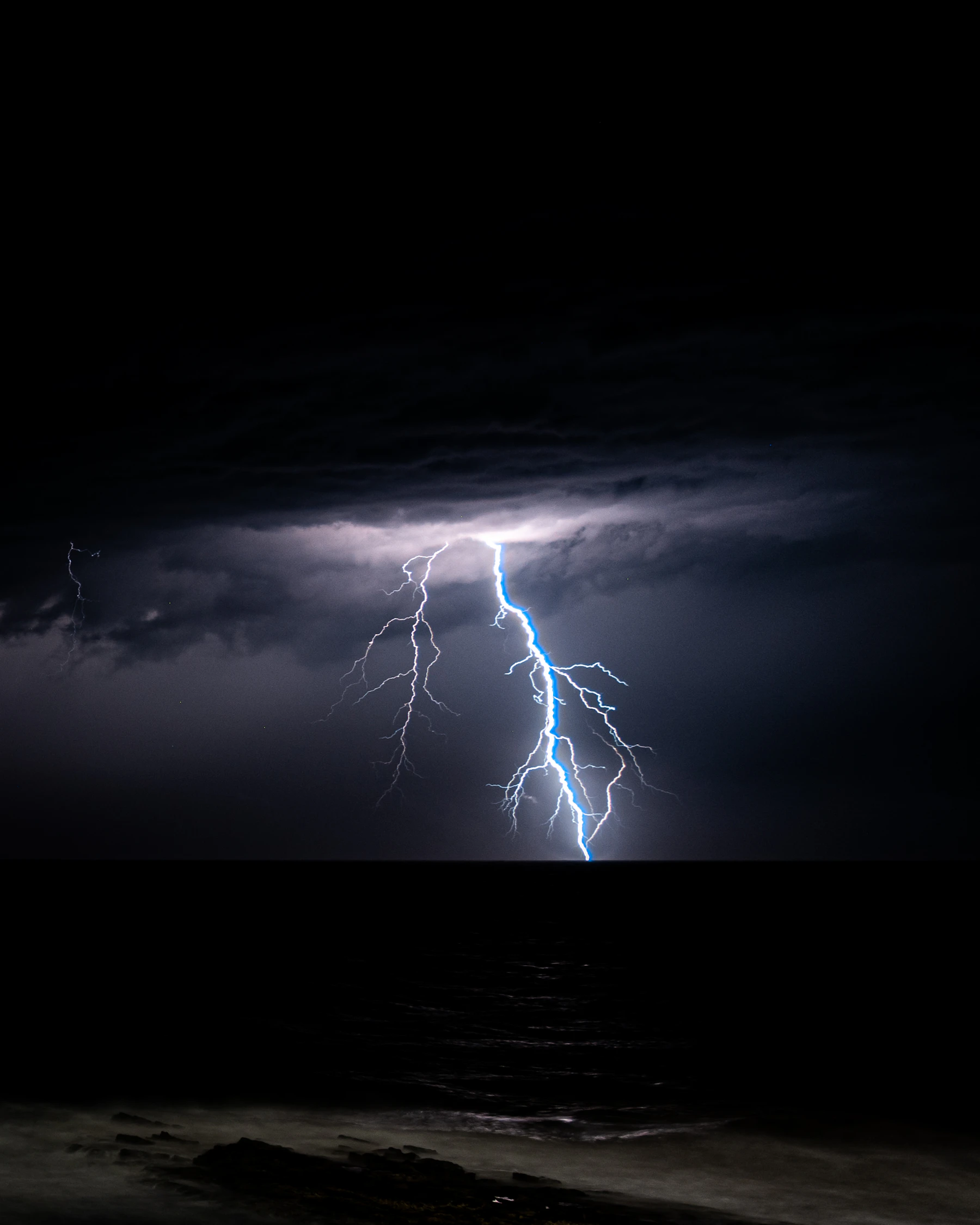 Un relámpago cae sobre el océano durante una tormenta nocturna
