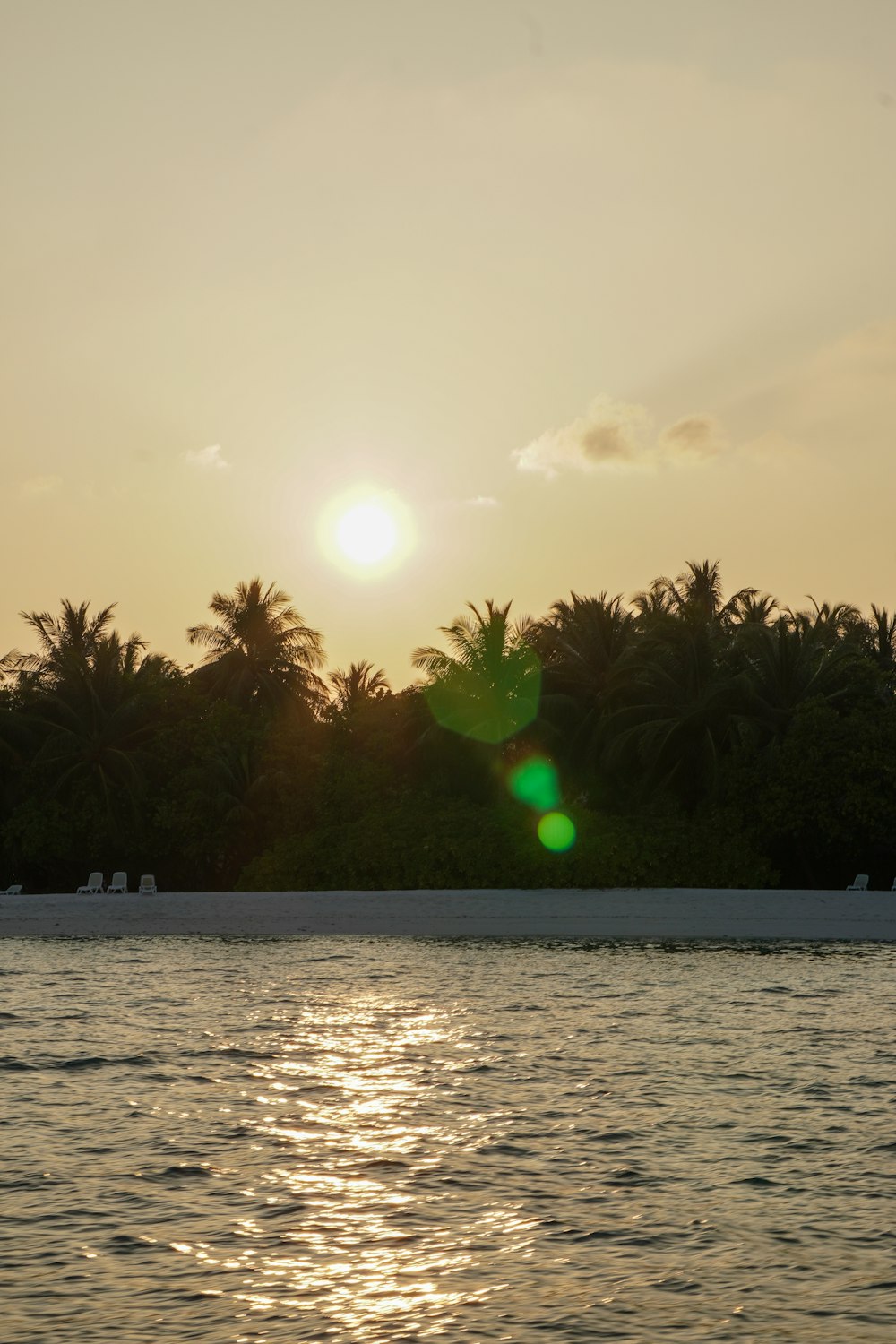 the sun is setting over a tropical island