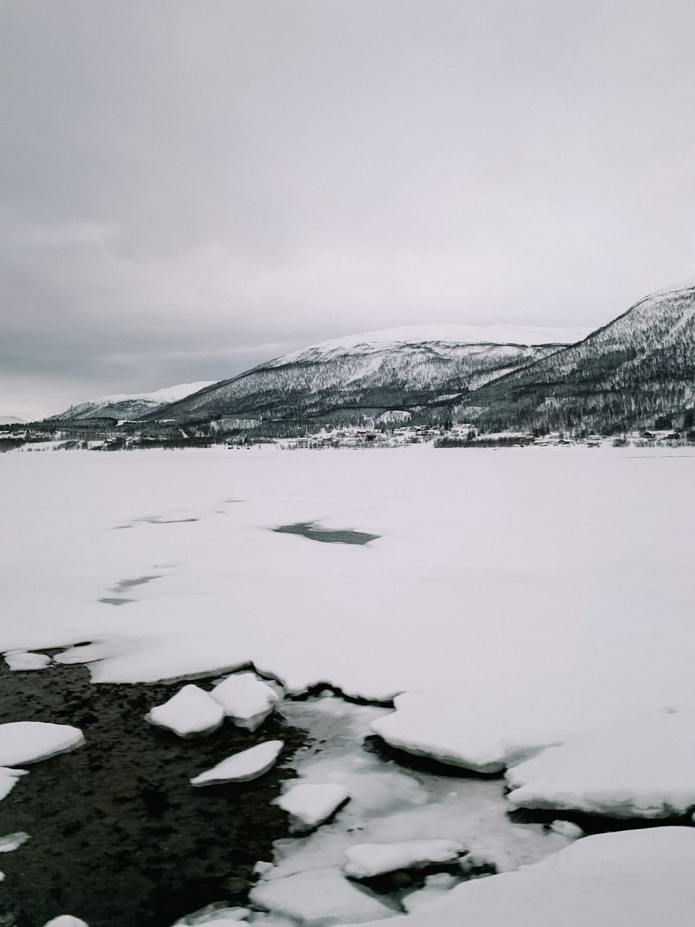 a large body of water surrounded by snow covered mountains