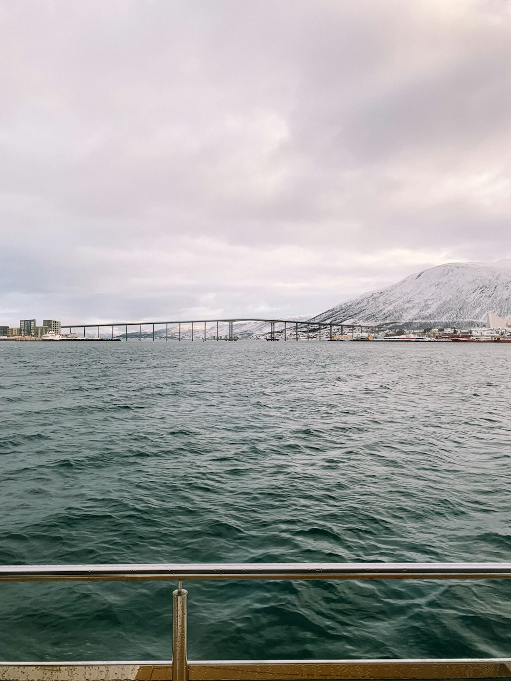 a large body of water with a bridge in the background