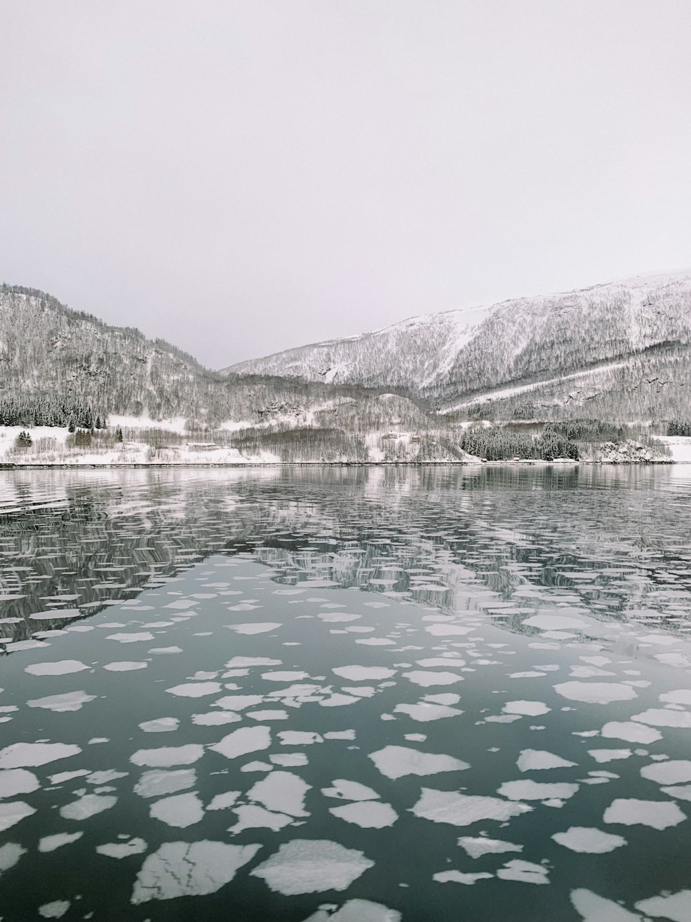 a large body of water surrounded by snow covered mountains