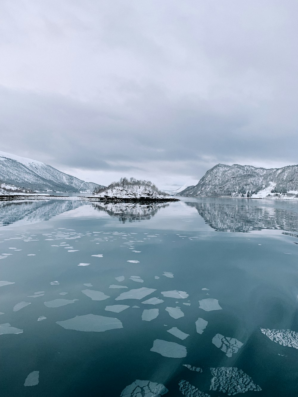 a large body of water surrounded by snow covered mountains