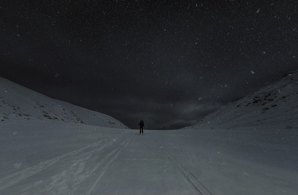 a person standing in the middle of a snow covered field