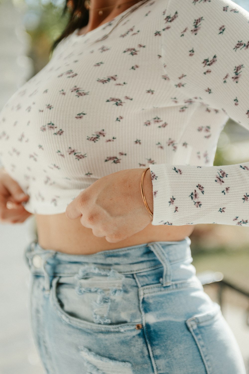 a woman wearing a white top and jeans