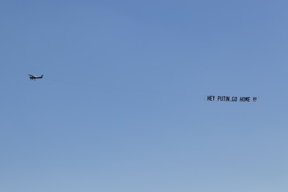 a plane flying in the sky with a message written on it