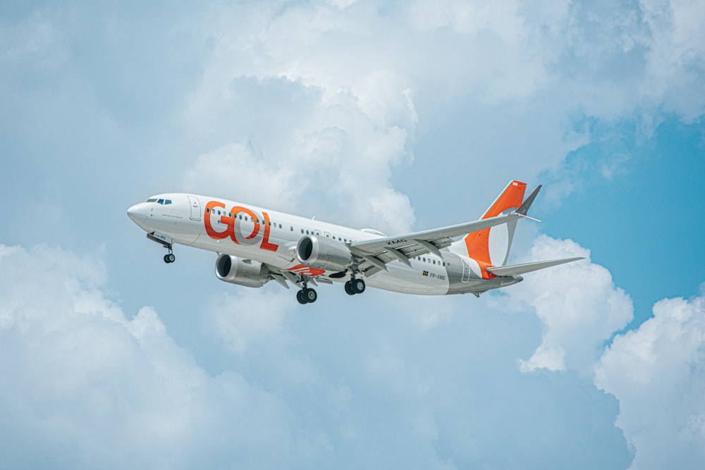 Un avion blanc et orange volant dans le ciel