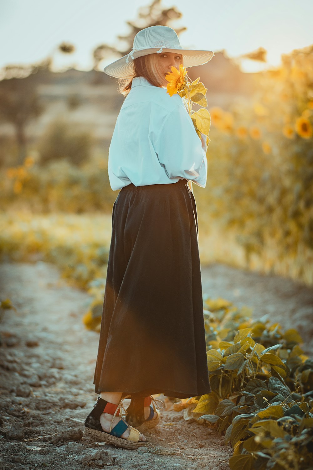 a woman in a white hat and a brown skirt