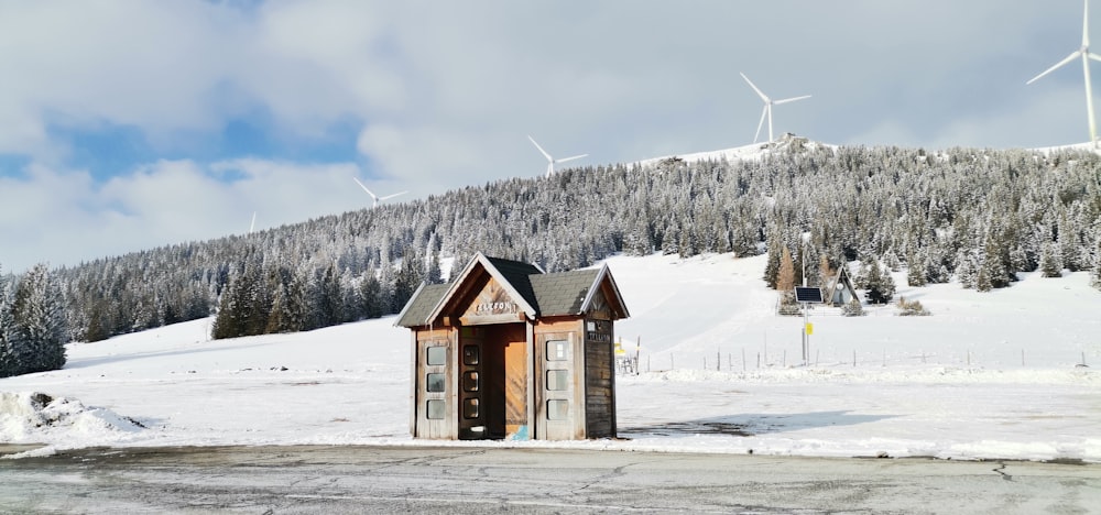 a small building sitting in the middle of a snow covered field