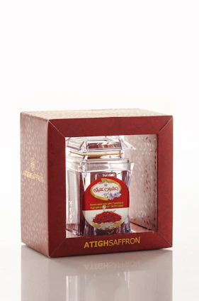 Close-up of vibrant Indian spices in elegant export-grade packaging with saffron and maroon accents.