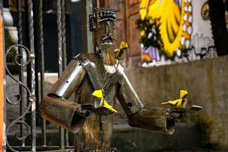 Community members crafting sculptures from reclaimed metal scraps outdoors.