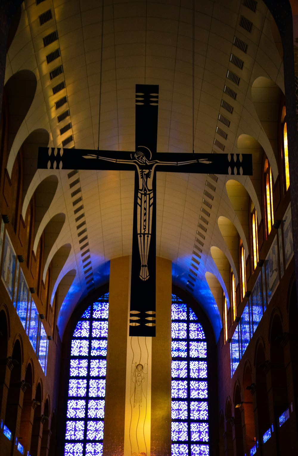 a large cross hanging from the ceiling of a church