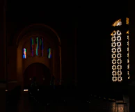 Wide shot of a modern interior with multiple stained glass artworks illuminating the space.