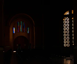 Interior of a music studio with colorful modernist stained glass windows inspired by Antoni Gaudí.