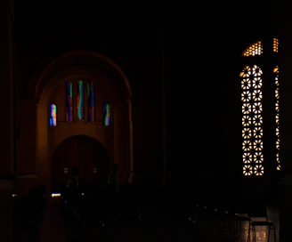 Wide shot of a modern interior with multiple stained glass artworks illuminating the space.