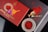 An elegant arrangement of saffron threads is displayed with a decorative red box and a traditional brass mortar and pestle. The box, labeled 'Premium Saffron,' features intricate designs and a floral element. The saffron is also presented in an ornate dish with geometric patterns.