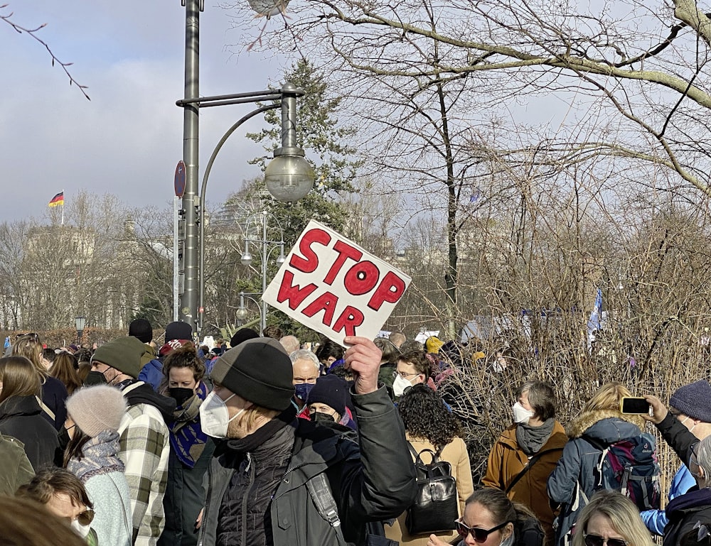 a crowd of people standing around each other holding signs