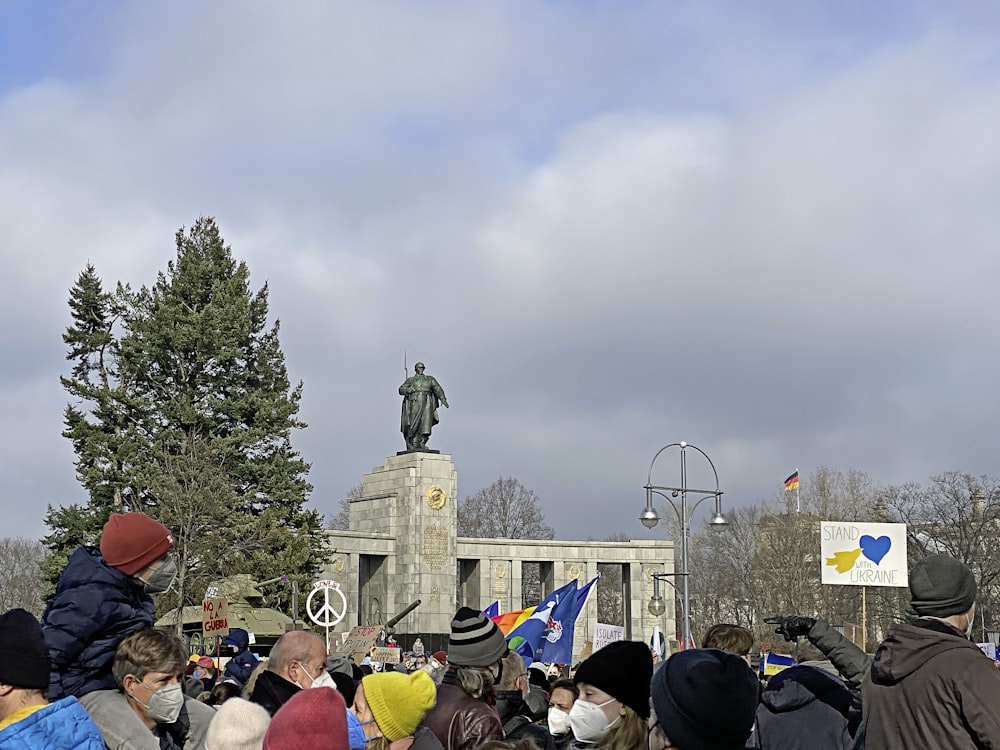 Una multitud de personas de pie alrededor de una estatua
