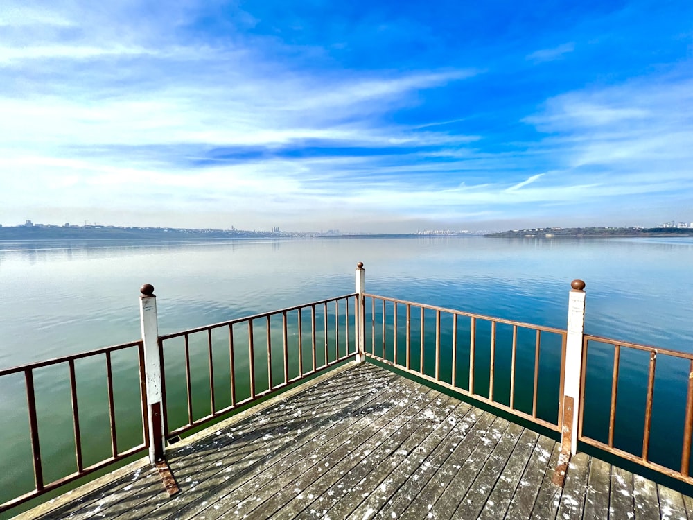 a wooden dock with railings leading to a body of water